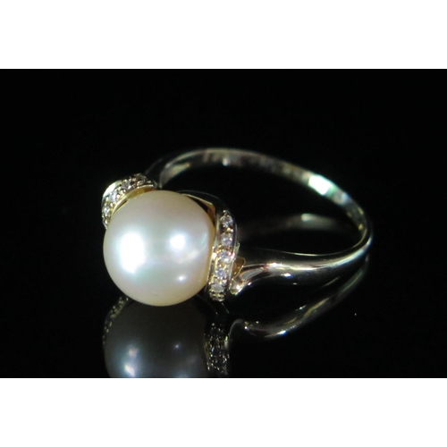 132 - A 14ct Gold, Cultured Pearl and Diamond Ring, c. 9.1mm pearl, size N.25, stamped 585 005, 3.37g