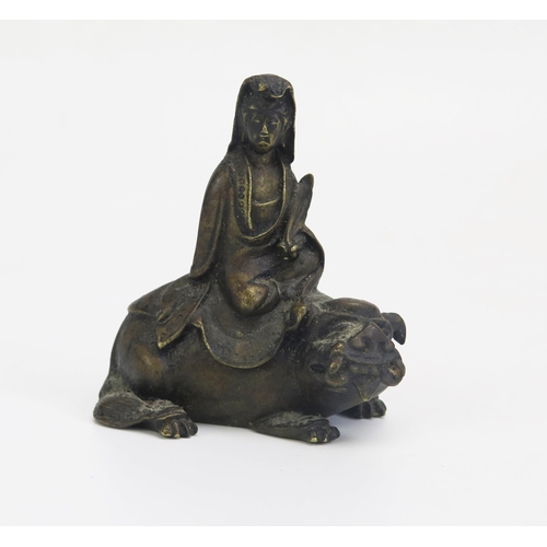 1328 - A Chinese bronze figure of Simhanada seated on the back of a temple lion, 8cm high.