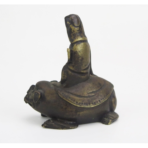 1328 - A Chinese bronze figure of Simhanada seated on the back of a temple lion, 8cm high.