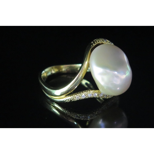 133 - An 18ct Gold, Baroque Pearl or Cultured Pearl and Diamond Ring, 19.5mm head, stamped 18K, .2ct of di... 