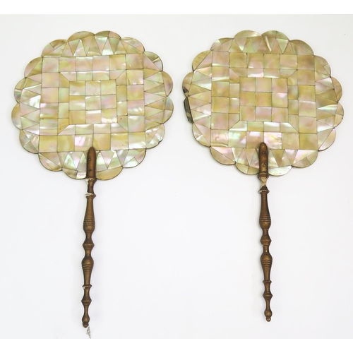 1337 - A pair of 19th century mother-of-pearl fans, of circular form mounted on turned gilt wood handles. O... 