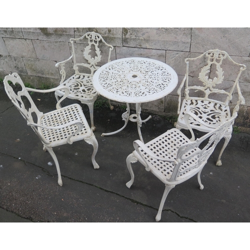 1505 - A cast alloy and white painted bistro set, includes circular table, tow elbow chairs and two non mat... 