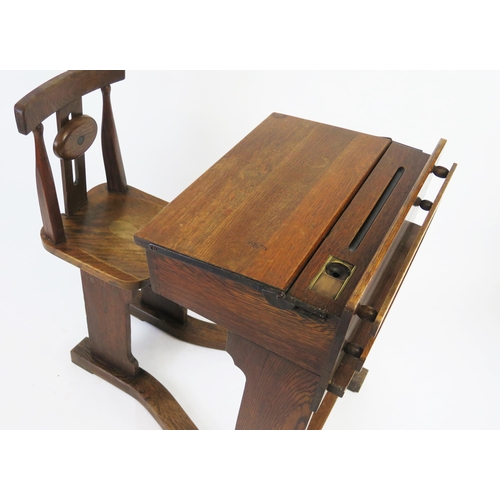 1512 - A late Victorian elm and beech school desk, the sloping hinged top, with pen tray and brass inkwell,... 