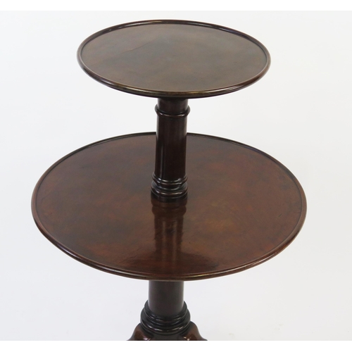 1517 - A 19th century mahogany two tier circular dumb waiter, of graduated form on a ring turned column, on... 