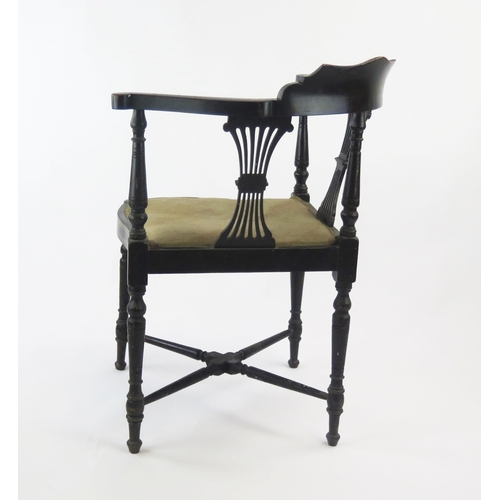 1534 - A late Victorian ebonised and inlaid corner chair, of serpentine outline with padded seat, on turned... 