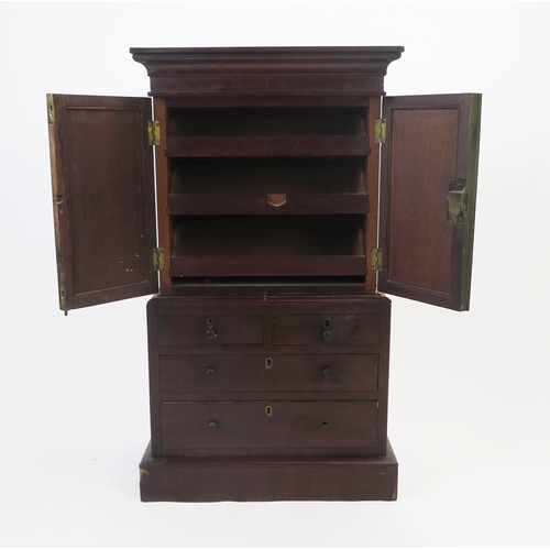 1535 - An apprentices miniature mahogany linen press, the top with a moulded cornice and a pair of panelled... 