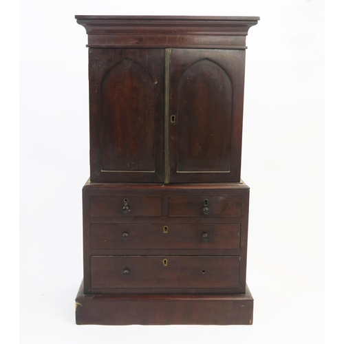 1535 - An apprentices miniature mahogany linen press, the top with a moulded cornice and a pair of panelled... 