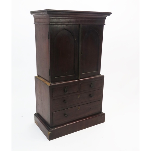 1535 - An apprentices miniature mahogany linen press, the top with a moulded cornice and a pair of panelled... 