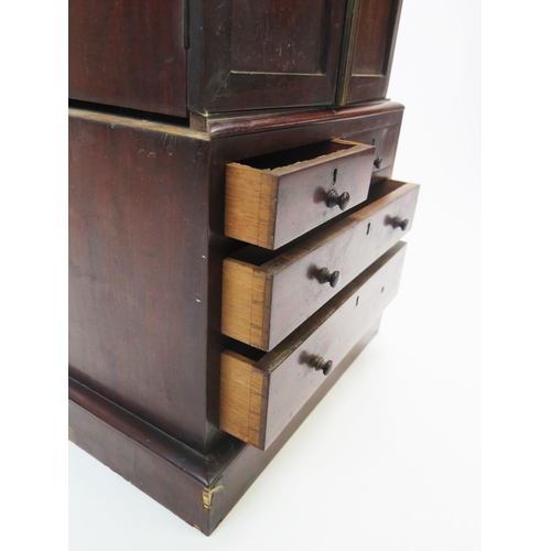 1535 - An apprentices miniature mahogany linen press, the top with a moulded cornice and a pair of panelled... 