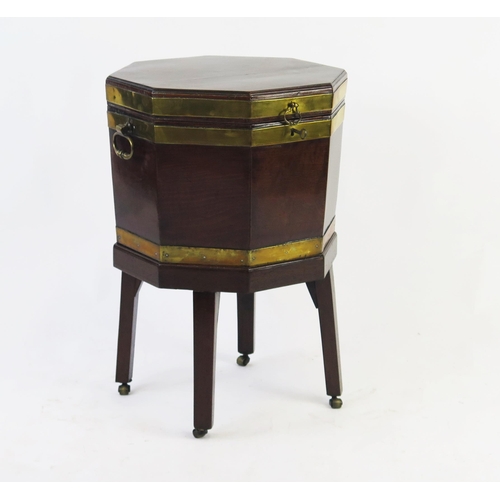 1536 - A George III mahogany and brass bound wine cooler, of octagonal outline, the hinged lid enclosing  a... 