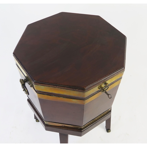 1536 - A George III mahogany and brass bound wine cooler, of octagonal outline, the hinged lid enclosing  a... 