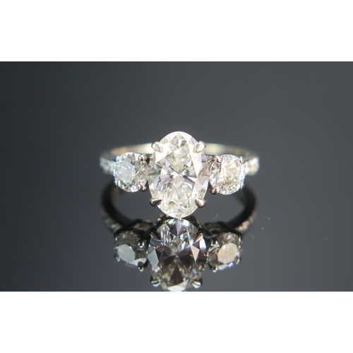 154 - An 18th White Gold and Diamond Three Stone Ring, the c. 10.2x7mm laboratory diamond with laser etche... 