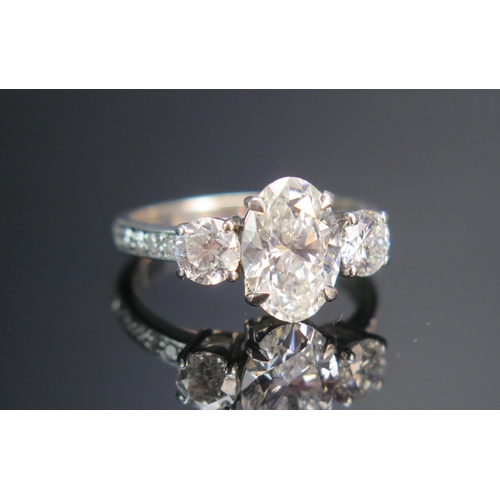 154 - An 18th White Gold and Diamond Three Stone Ring, the c. 10.2x7mm laboratory diamond with laser etche... 