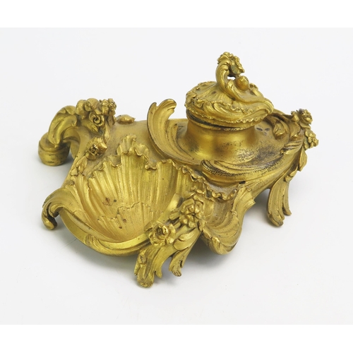 1550 - A 19th century ormolu inkwell in the Rococo style, with hinged lid, swept scrolls and flowerhead dec... 