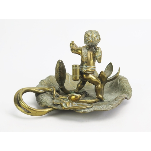 1551 - A late Victorian gilt brass pen stand, with revolving 21cm wide cherub and butterfly snuffer to a fl... 