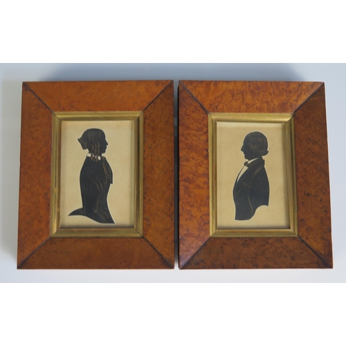 1554 - A pair of 19th century silhouettes of a lady and gentleman, with detail heightened in gilt, containe... 