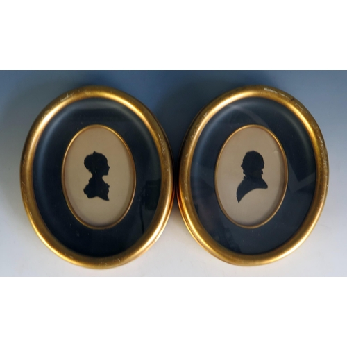 1556 - A pair of 19th century silhouettes of a lady and gentleman, contained in oval gilt frames. 12 x 7cm ... 