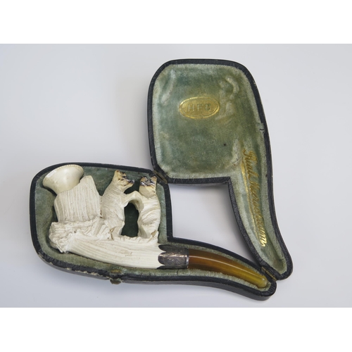 1571 - A carved meerschaum pipe, decorated with two bears, with silver mounted amber mouthpiece, cased.