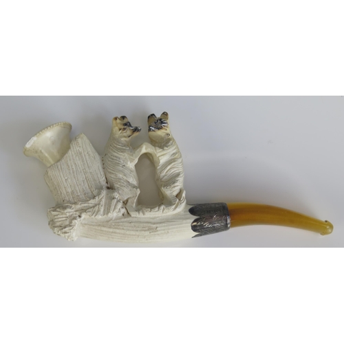 1571 - A carved meerschaum pipe, decorated with two bears, with silver mounted amber mouthpiece, cased.