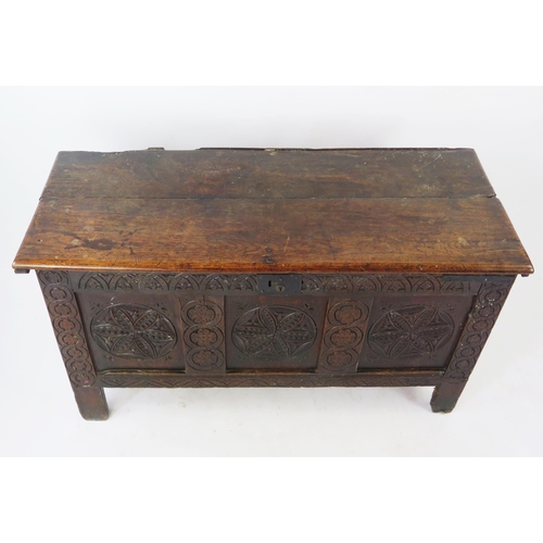 1573 - An 18th Century carved oak coffer of rectangular outline, with triple carved panel front, raised on ... 