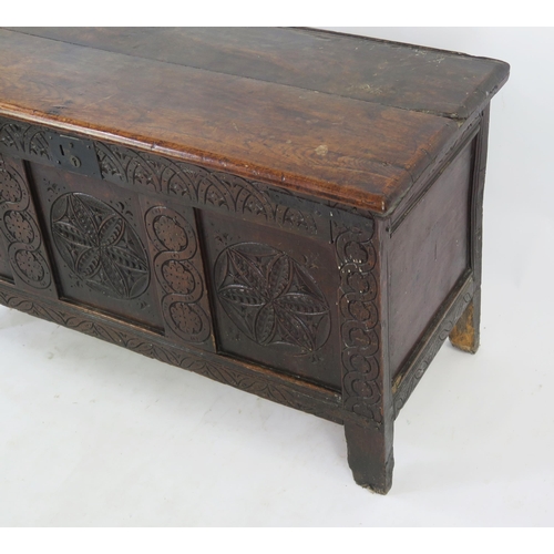 1573 - An 18th Century carved oak coffer of rectangular outline, with triple carved panel front, raised on ... 