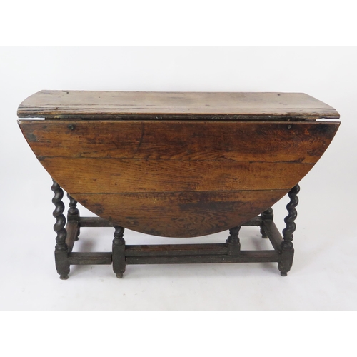 1574 - An 18th century oak drop flap table, the top with two hinged leaves on a gate leg action, the spiral... 