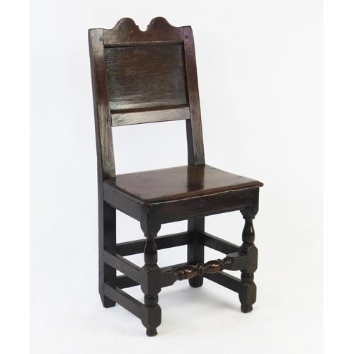 1582 - A late 18th century oak hall chair, with double arched top rail, panelled back and solid seat on tur... 