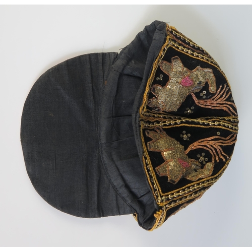 1616 - An Indian black silk and velvet cap with applied sequin decoration in the form of elephants.