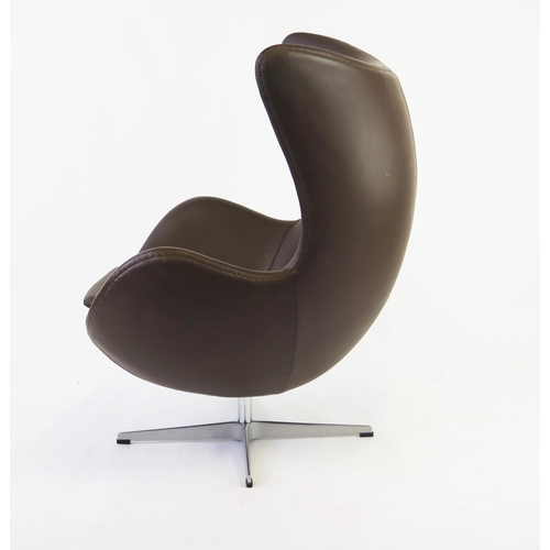 1627 - An Arne Jacobsen style, brown leatherette egg chair on chrome cruciform swivel base.