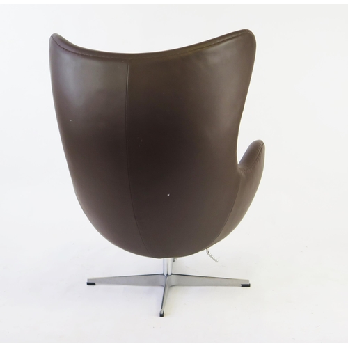 1627 - An Arne Jacobsen style, brown leatherette egg chair on chrome cruciform swivel base.