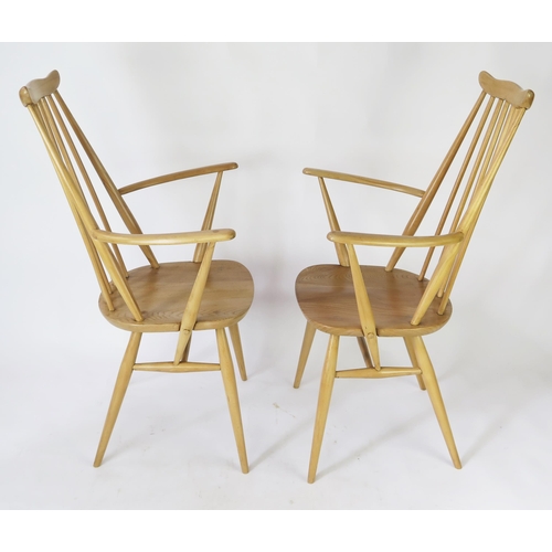 1633 - A pair of Ercol Goldsmith carver chairs, with solid seats on turned under framing. (2).