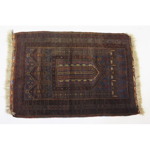 1692 - A Caucasian prayer rug, the main wine red geometric field with arched mirab, enclosed by a triple me... 