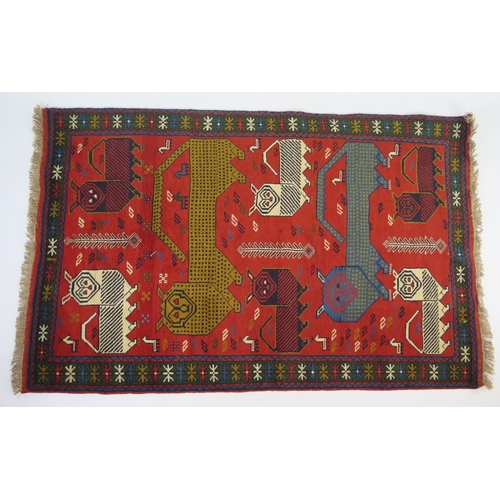 1693 - A Gouchan rug, the tomato red field decorated with eight stylised tigers and leopards, enclosed by a... 