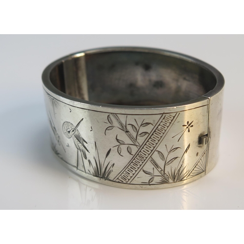 192 - An Antique Precious White Metal Hinged Bangle with aesthetic engraving, 25.87g