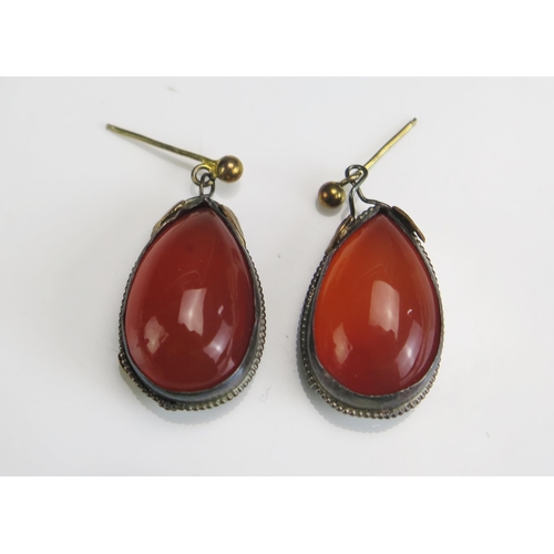 233 - A Pair of Agate Pendant Earrings in a precious white metal setting with yellow metal highlights, c. ... 