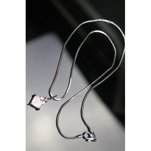 298 - An 18ct White Gold Invisible Set Diamond Pendant20mm drop, stamped 750 on a white metal chain, 5.27g... 