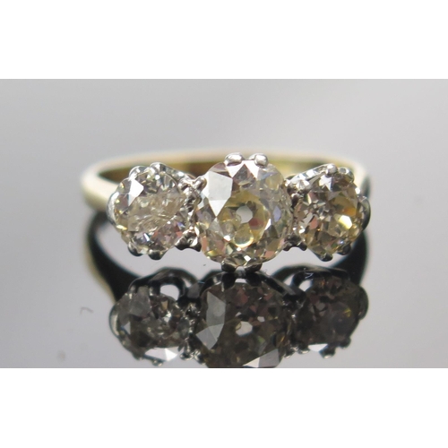 318 - An Old Cut Diamond Three Stone Ring in a high carat precious yellow metal setting, c. 6.2x5.4mm prin... 