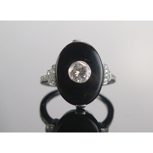 329 - A Modern Onyx and Diamond Ring in a precious white metal setting, c. 4.85mm principal brilliant roun... 