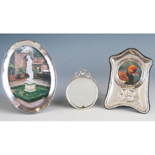 539 - A silver framed photograph frame of oval outline, 16cm high, together with  another photograph frame... 