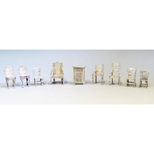 545 - A collection of continental silver miniature chairs and cabinet, various designs, total weight of si... 