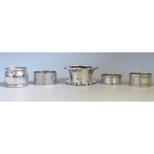 561 - Four assorted silver napkin rings, various makers and dates, together with a silver octagonal stand,... 