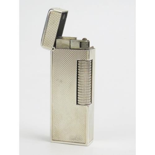 590 - Dunhill, a silver cased Rollagas lighter, bears import marks, 6.5cm high.