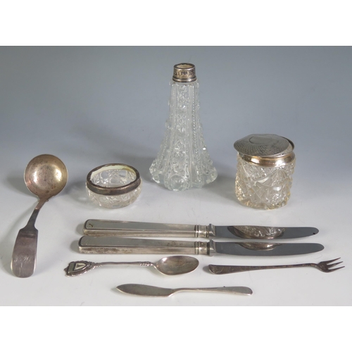 629 - A mixed collection of silver wares, includes clear glass and silver mounted jars, silver handled kni... 