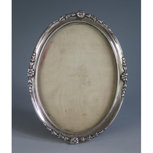 646 - A George V oval silver photograph frame, maker Mappin & Webb, London, 1910, with applied floral deco... 