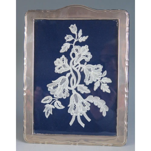 679 - A George V silver photograph frame, maker's mark worn, Birmingham 1913, containing a lace work flora... 