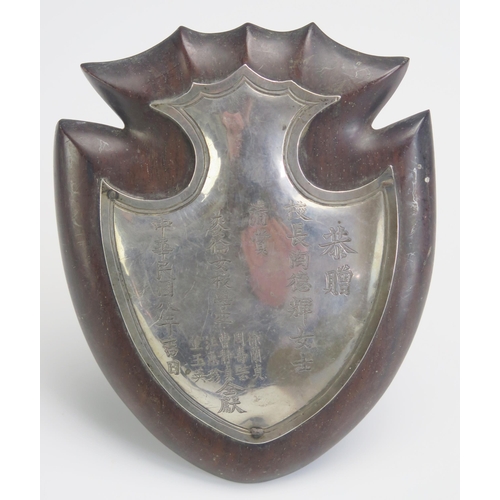 691 - A Chinese silver miniature shield, mounted on a hardwood plaque, inscribed with characters, 16cm hig... 