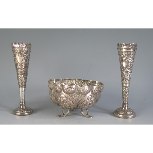 693 - An Indian silver bowl of lobed form with embossed foliate panels, raised on the swept feet, 10cm dia... 