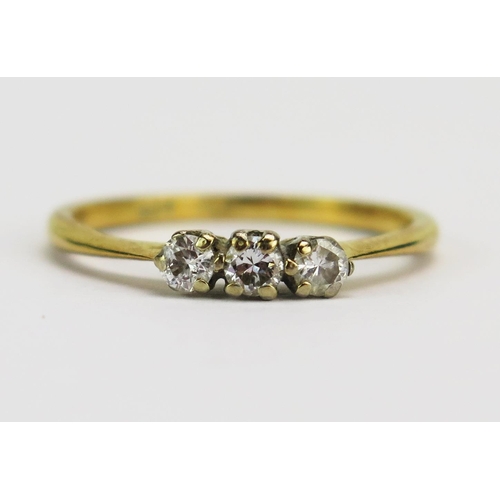 22 - An 18ct Gold Three Stone Diamond Ring, c. 2.7mm brilliant round cuts in a platinum claw setting, sta... 