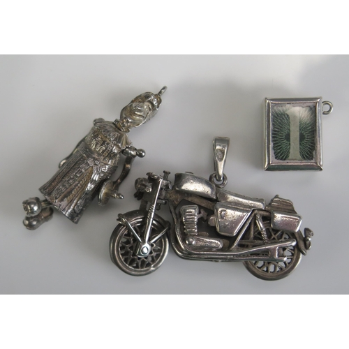 230 - A Silver 1 Shilling Note Charm, silver motorbike pendant and a precious white metal 'Judy' pendant, ... 