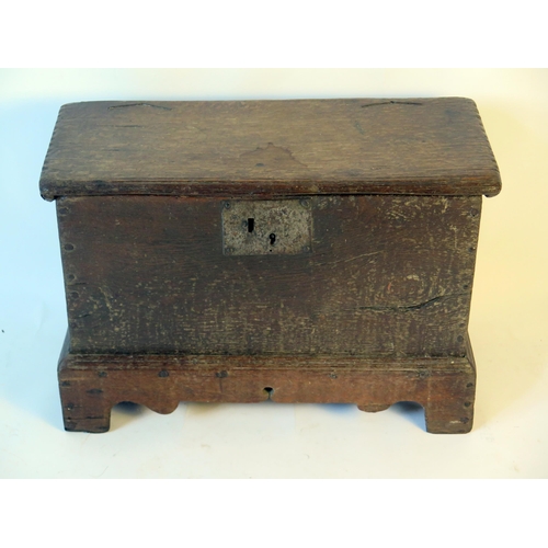 1579 - An 18th century small coffer, with rectangular hinged top, and plain sides on plinth base with brack... 